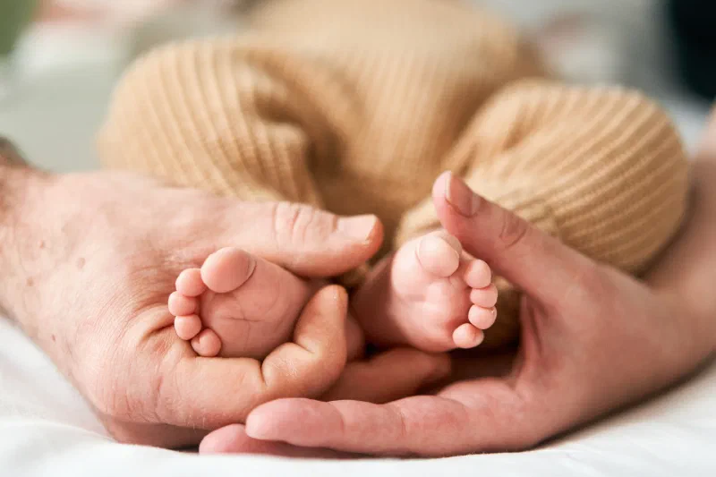 At-home newborn photographer Newcastle cuddling baby